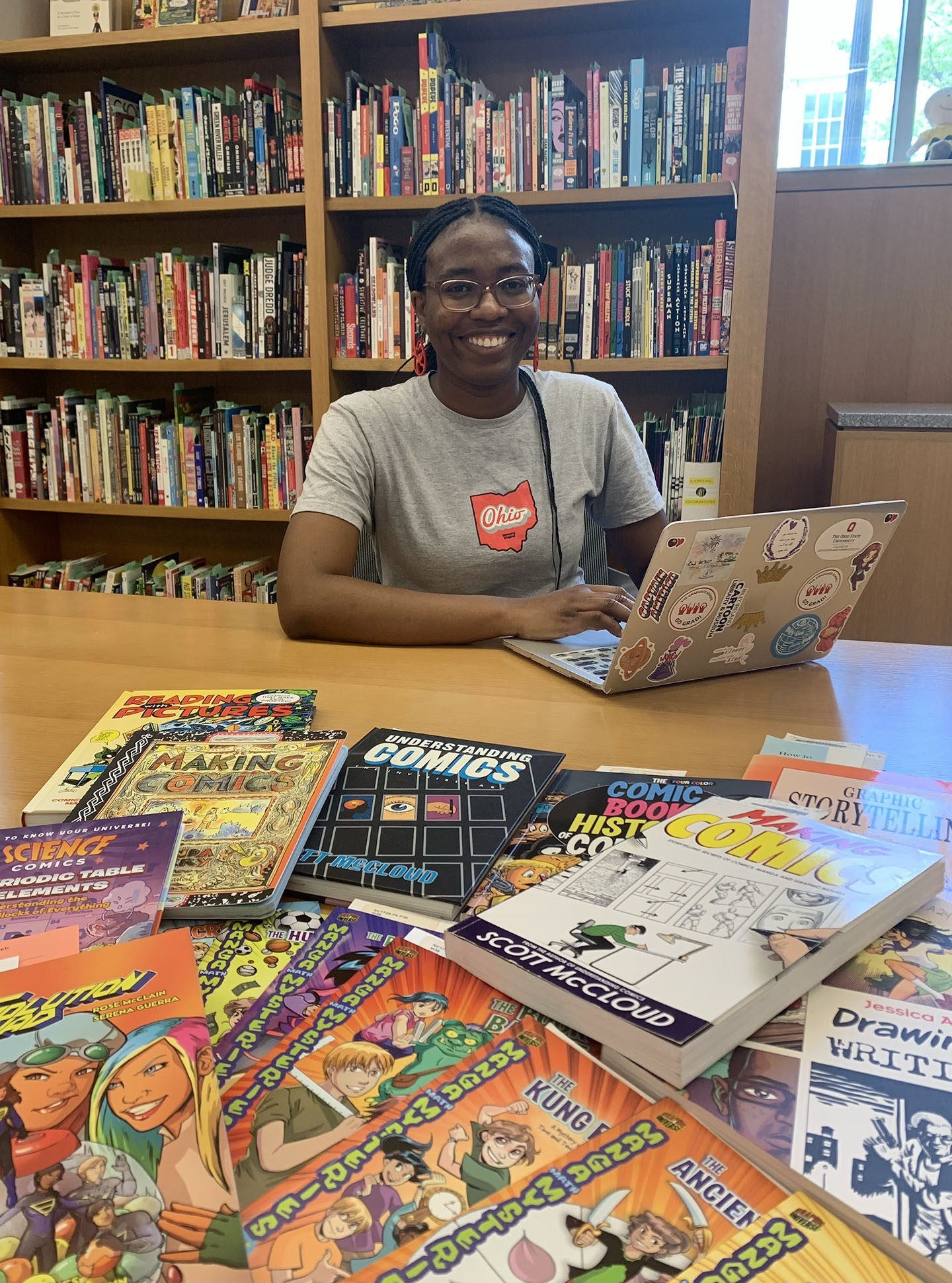 Photograph of scholar at library desk with comic books