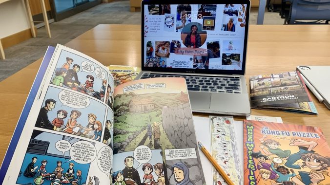 Laptop and comics on a desk displaying Ruth Oliwe's research