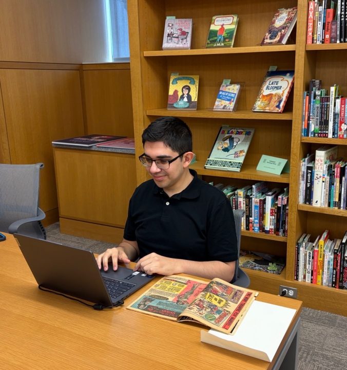 Sebastian Martinez using laptop in library reading room