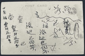 A handwritten note in Japanese on the back of a postcard on a black background.
