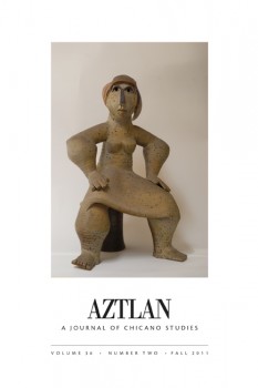Stone sculpture of woman seated facing forward with hands on thighs.