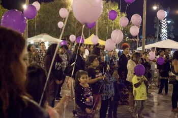 Children and Adults holding purple balloons