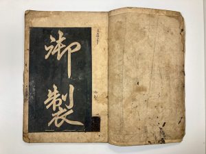 A open calligraphy book with two large handwritten Chinese characters